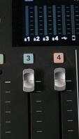 Adjusting audio faders on mixing console video