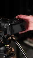 Camera operator adjusting settings on digital screen video
