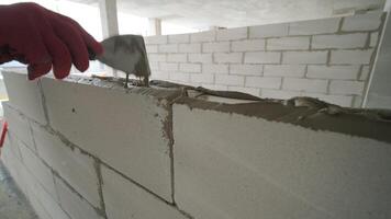 The master performs laying a wall of gas blocks with tools and adhesive mortar 3 video
