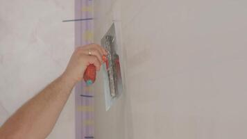Man plastering the walls with finishing putty in room with putty spatula 5 video