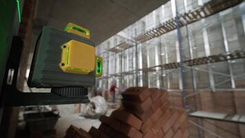 The builder measures the repair lines using a green laser level 2 video