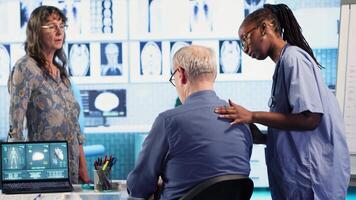 Healthcare expert conducts a physical routine checkup on senior patient, addressing spinal issues and providing solutions for pain management and improved mobility in a clinic. Camera B. video