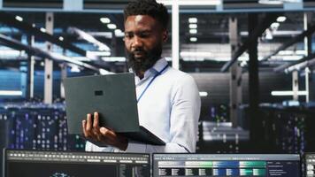 Happy data center admin uses node tree programming on laptop, doing high five with coworker. Smiling server farm worker greeting colleague, reviewing data analysis graph, camera B video