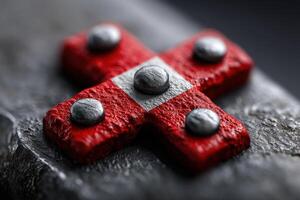 Metalwork featuring a red cross design with silver accents on a textured surface photo