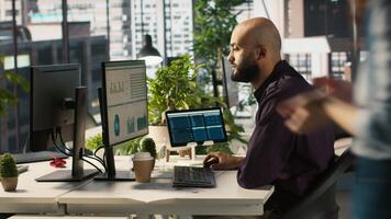 Arab office clerk working to hit key performance targets for revenue, profitability and operational efficiency. Middle Eastern employee at PC desk doing research analysis, camera A video