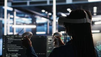 Server farm admin using VR equipment and node tree systems to categorize unstructured data. Data center IT specialist uses virtual reality headset and visual programming software, camera B video