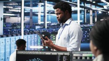 Data center technician uses node tree programming interface to identify equipment performance issues. Engineer reviews data analysis graph in server hub to minimize hardware failures, camera B video