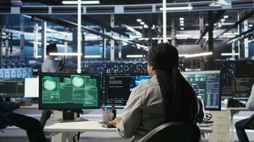 Vertical Technicians in AI server hub collaborate to protect against data theft during active threat. Data center team working together to safeguard equipment and systems during security breach, camera A video