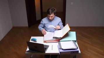 kantoor arbeider onderzoeken documenten met vergroten glas Bij bureau video