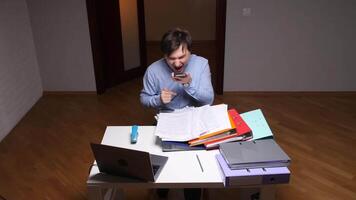 Stressed office worker shouting on phone while pointing at documents, anger video