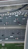 High-angle aerial top view of dense traffic flowing on multilayered highways and overpasses in Dubai at rush hour. Modern urban infrastructure, transport network, and daily city commute concept video