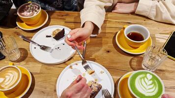 Slow motion sequence of friends enjoying cake and drinks at cafe, highlighting shared experience and simple pleasure of social gathering. Friends sharing cake and drinks at cafe, joyful social moment video