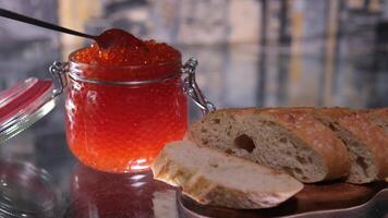 red caviar, rotation in circle. Spreading red caviar on loaf slice with spoon. Preparing festive sandwich video
