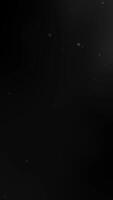 Black vertical background with white dust particles. Great for adding a mysterious and textured background to posters, or designs video