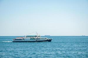 Stunning yacht cruising in clear blue ocean with distant horizon under clear sky. Happy summer days, travel and vacation concept photo
