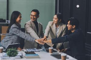 Asian business people shaking hands at a table photo