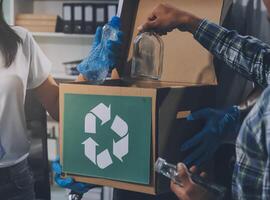 A man and woman are holding a box with a recycling symbol on it photo