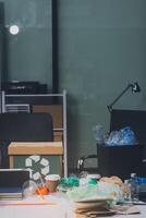A desk with a laptop, a trash can, and a cup of coffee photo