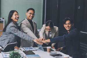 Asian business people holding hands in a meeting photo