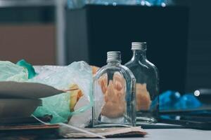 A table with a garbage can, bottles and a computer photo