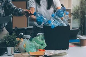 A man and woman are working on a desk with trash and plastic bottles photo