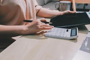 A woman is using a calculator and a tablet computer photo