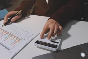 A person in a business suit is working on a calculator photo