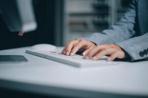 A person in a suit is typing on a computer keyboard photo