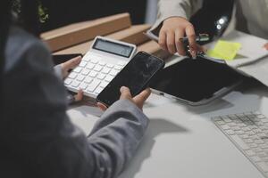 Two people are working on a computer and a cell phone photo