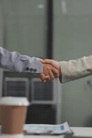 Two people holding hands in front of a desk photo