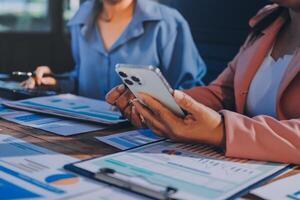 Business people using smartphones at a table photo