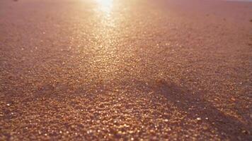 A close-up view of sunlit sand on a beach, capturing the shimmering texture and warm colors. photo