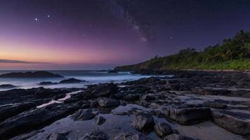 A serene beach scene at twilight, showcasing rocks, gentle waves, and a starry sky with the Milky Way. photo