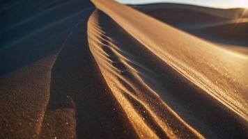 A close-up view of sand dunes illuminated by sunlight, showcasing natural textures and patterns. photo