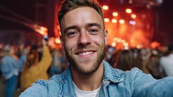 Cheerful Man Taking Selfie at Concert Vibrant Background Copyspace for Memorable Moments photo