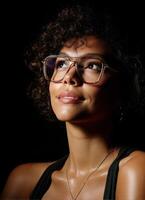 Inspiring portrait of a young woman with glasses studio setting photography dramatic lighting upward perspective photo