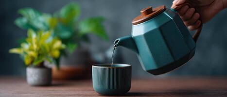 Pouring green tea from a teapot into a cup cozy home setting photography calm environment close-up perspective photo