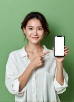 Engaging woman pointing at smartphone display indoor green background portrait photography positive vibes photo