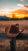 Cowboy Hat at Sunset on a Rustic Fence photo