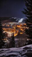 Enchanting Winter Village at Night with Snowy Mountains photo