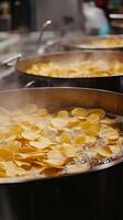 Frying potato chips in sizzling oil, close view photo