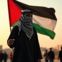 A man in a traditional palestinian dress stands in front of a palestinian flag photo