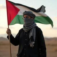 A man holds a flag of palestine in the desert photo