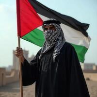 A man in a traditional palestinian dress holds a palestinian flag in the desert photo