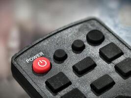 Close-Up of Remote Control Power Button Highlighting Detailed Red and Black Texture photo
