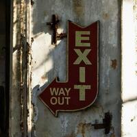Vintage Exit Sign with 'WAY OUT' Displayed on a Weathered Industrial Wall photo