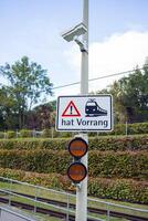 Warning signals and a sign at a railway crossing. A surveillance camera is installed at a railway crossing. photo