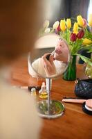 Lipstick being applied in front of a mirror, surrounded by scattered makeup tools. photo