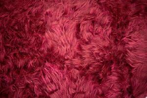 close up Luxurious long haired velvet in a deep wine red shade background photo