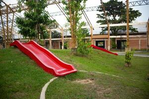 Red slide on grassy slope in unfinished building structure photo